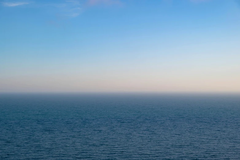 a lone boat on the ocean in the distance