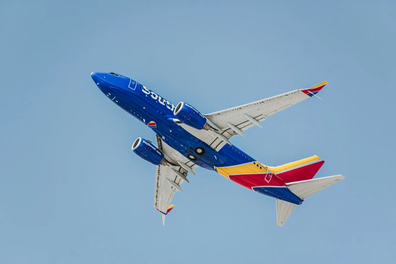 a very colorful plane flying overhead by the camera