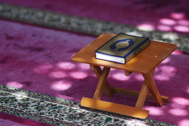 a small wooden table on a purple rug