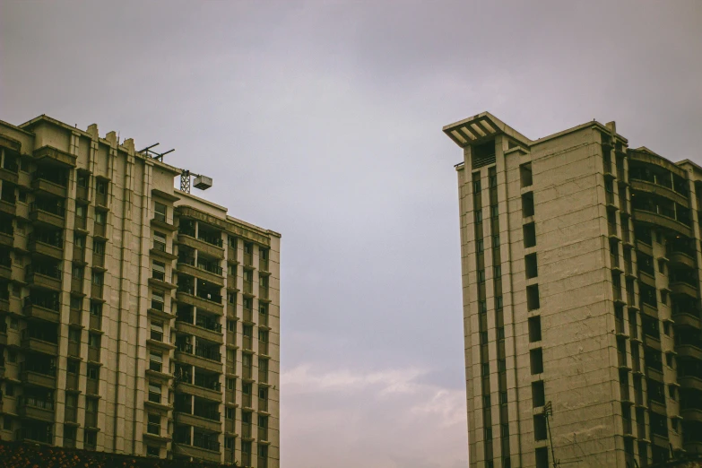 two tall buildings with a clock tower behind them