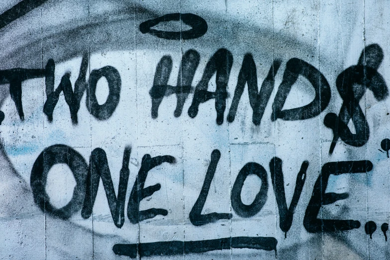 a graffiti wall with the words two hands one love on it