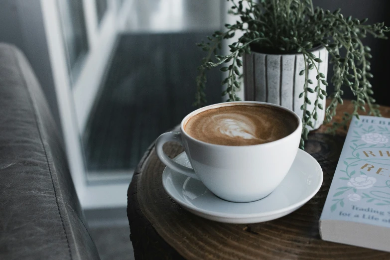 there is a coffee cup and a small book