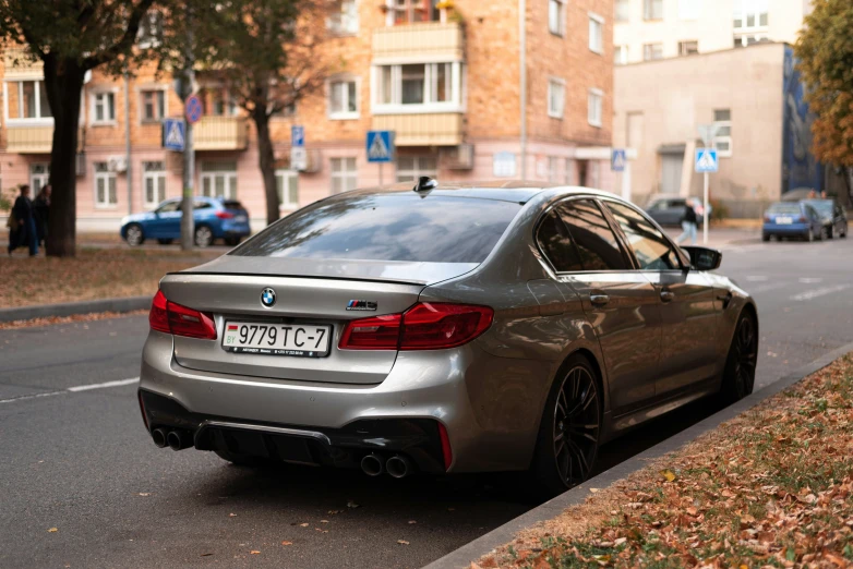 a grey car parked at the curb in front of some buildings