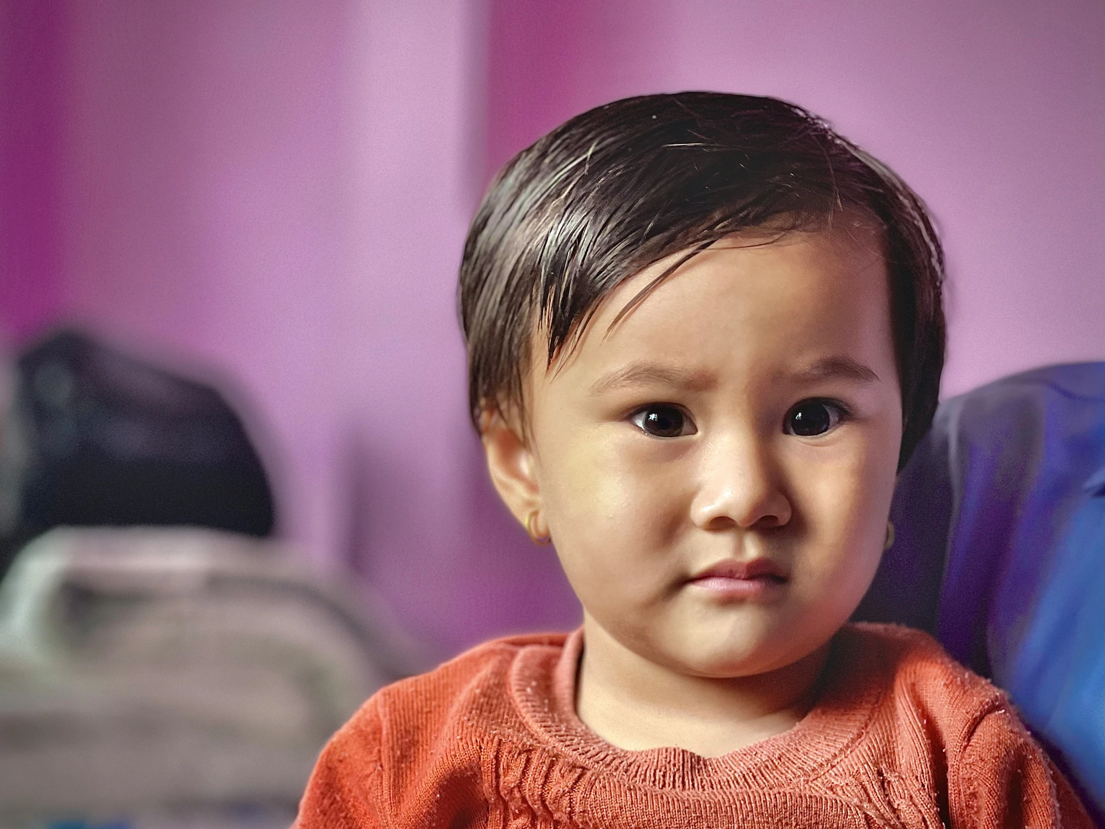 a small child sits at the foot of a bed