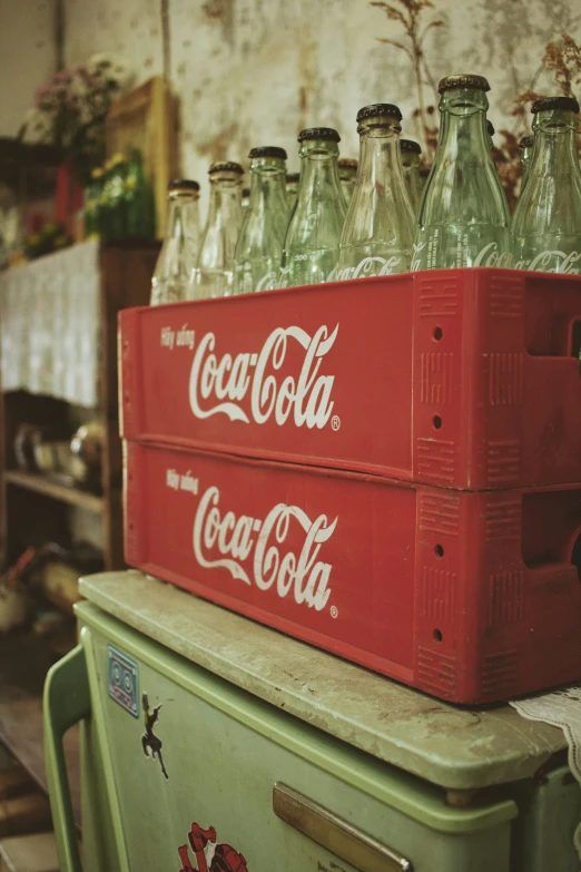 three crates sitting on top of an old refrigerator