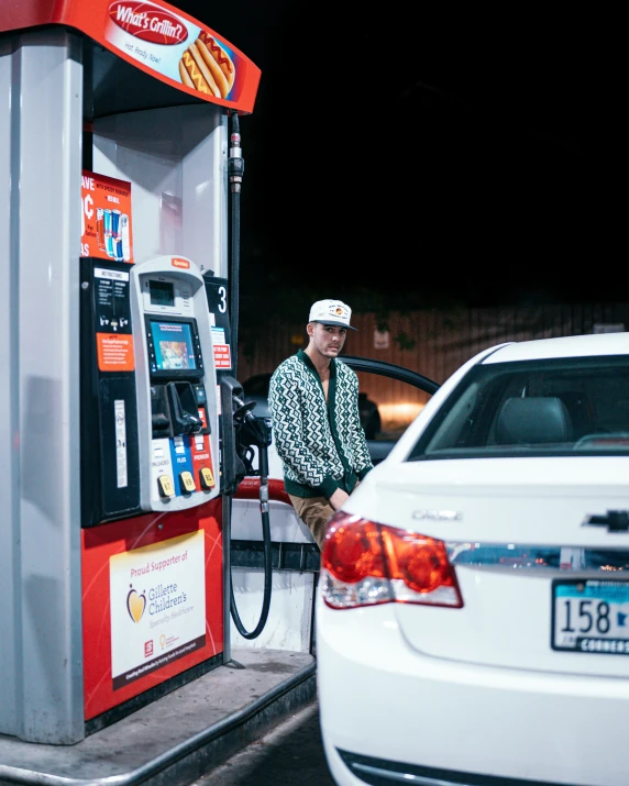 a man in a white hat at a gas station