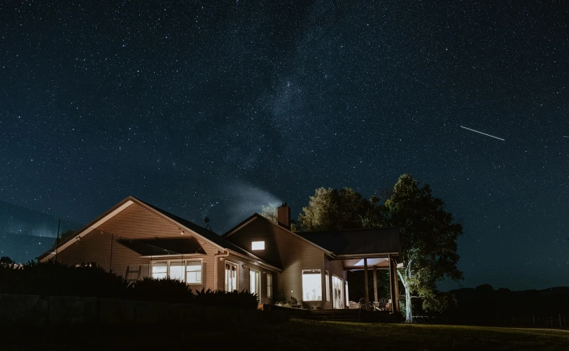 a night time po of a house with the sky full of stars