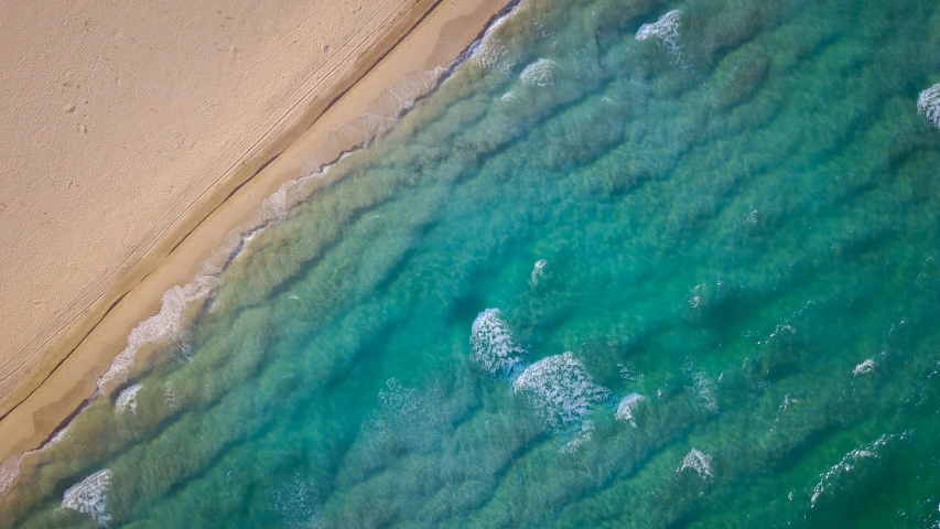 an aerial view of a beach and blue water