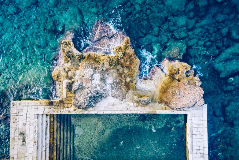 a aerial view of the water and rocks in a city