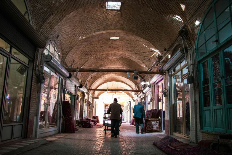 a person walking down an indoor market near shops