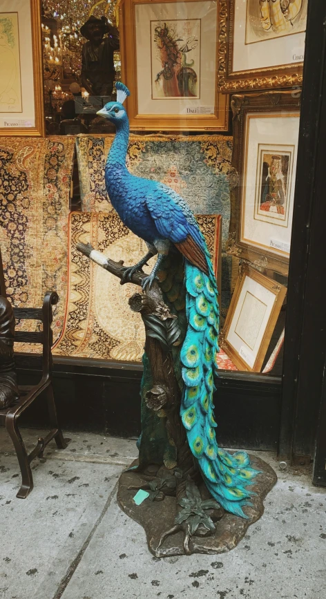 a statue of a blue bird sitting on top of a bench