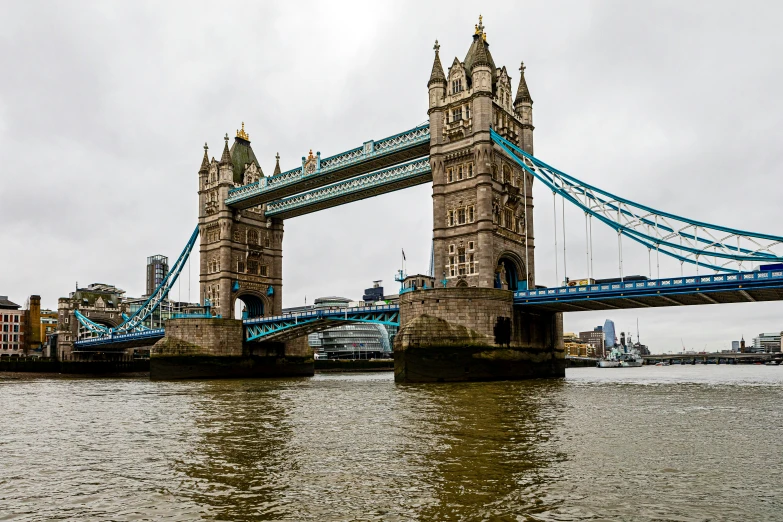 a bridge with people crossing over it across a river