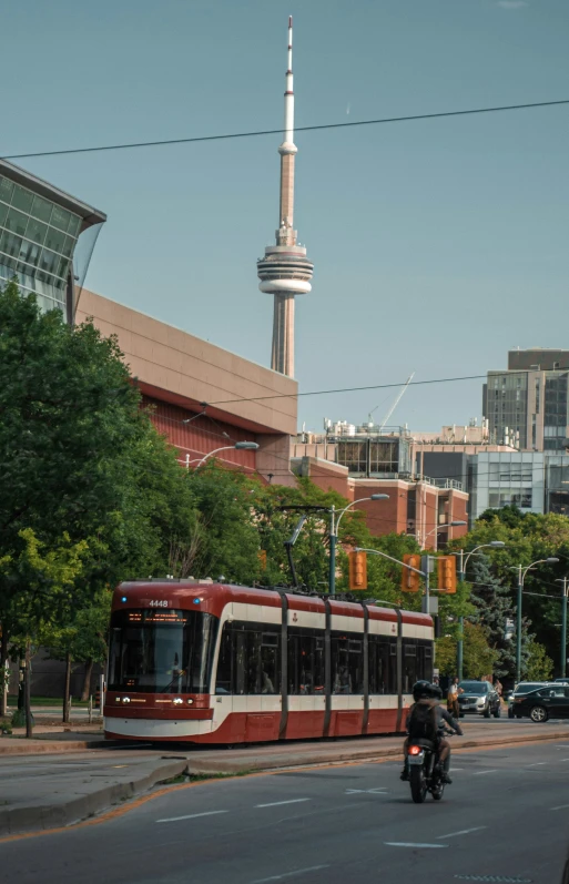 a city bus on a road with buildings in the background