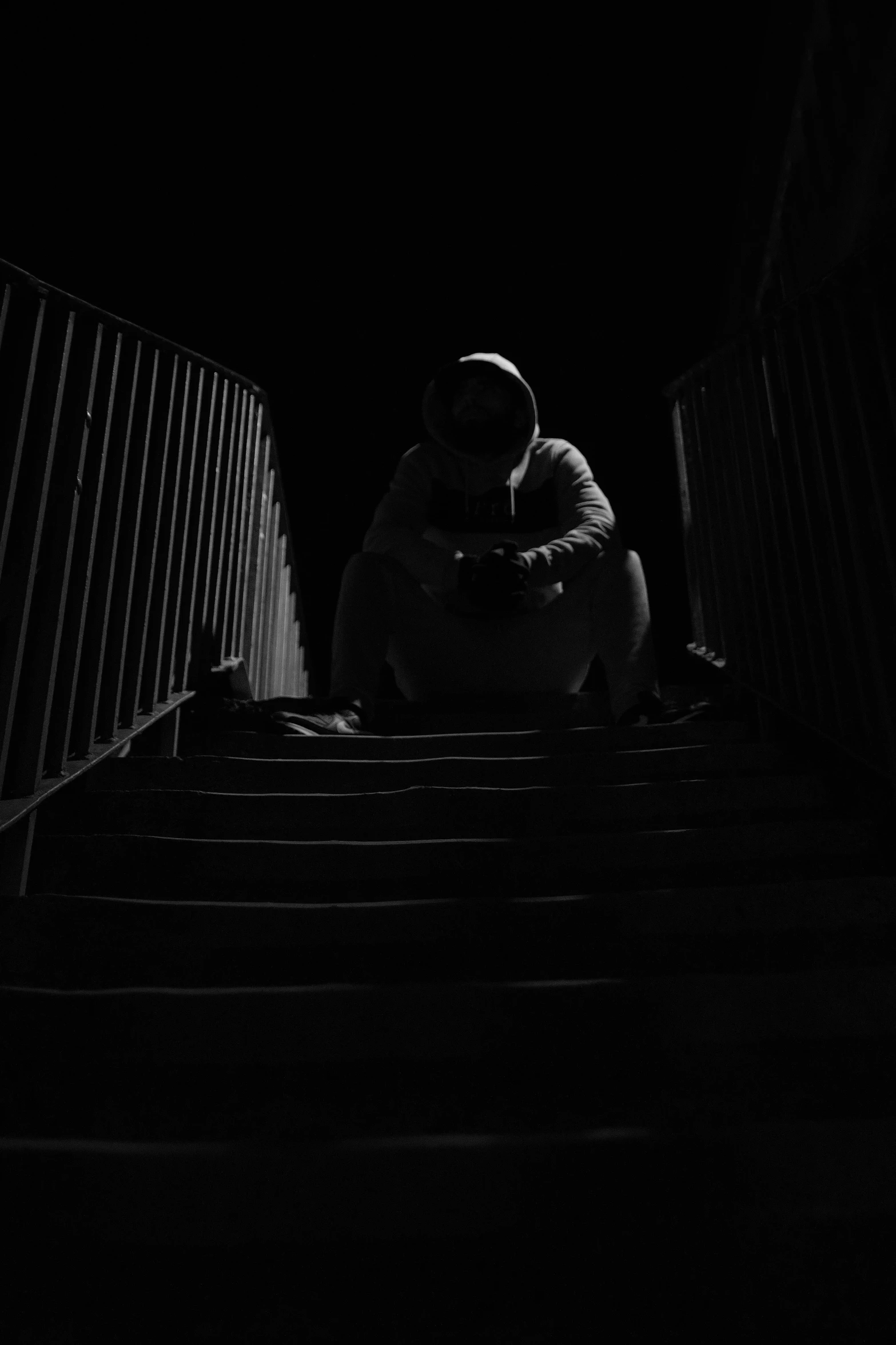 black and white pograph of person kneeling down stairs