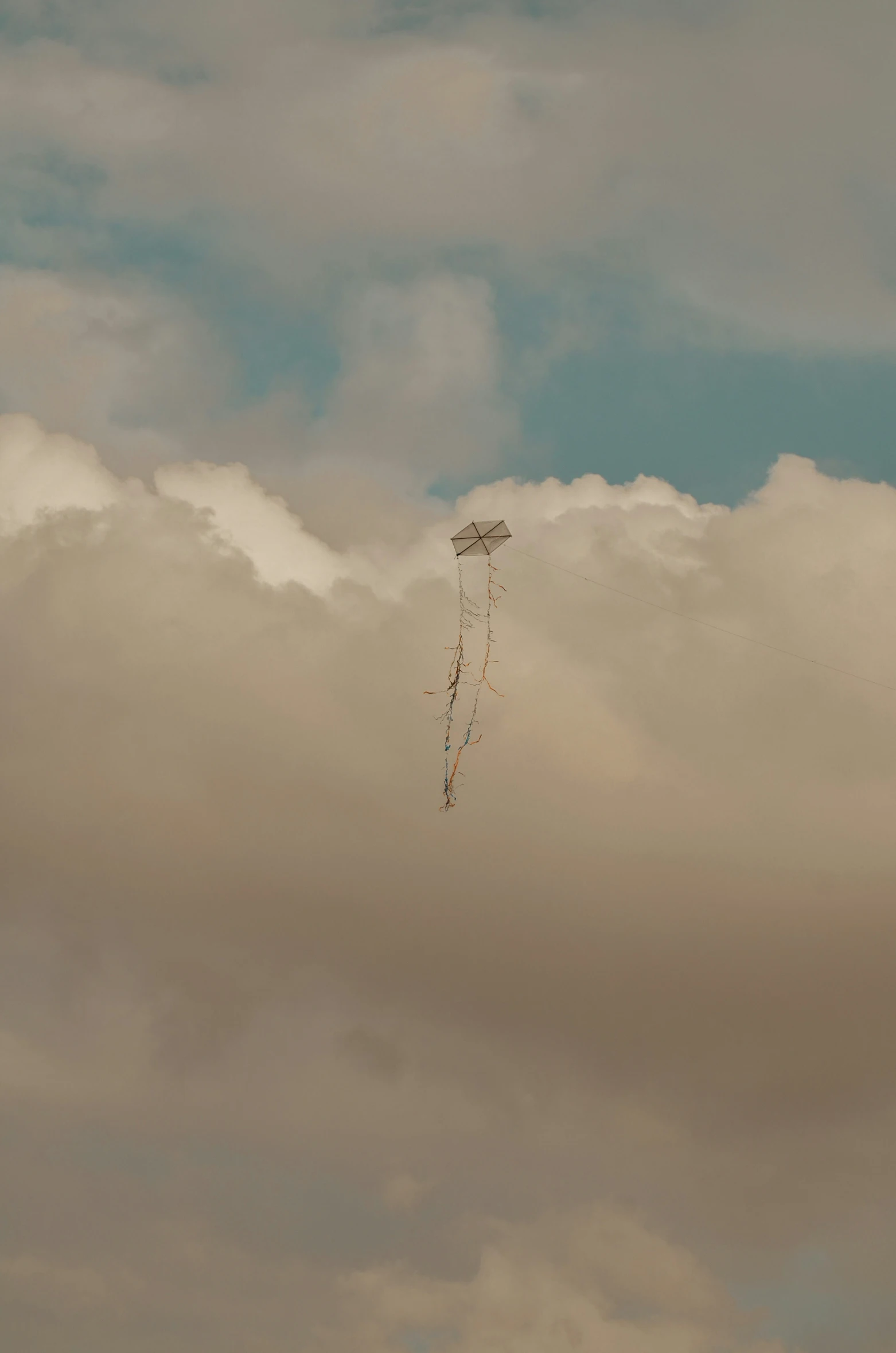 a kite flying on cloudy skies in the daytime