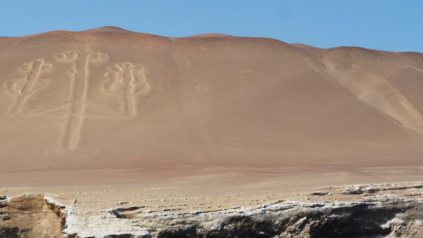 a group of people are on a desert with mountains behind them