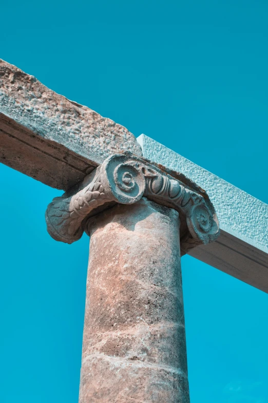 a stone column that has a gargoyle sculpture on top