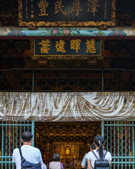 two men and a child in front of a gate