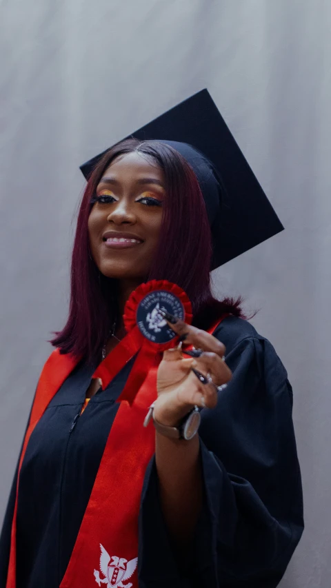 a woman dressed in her college graduation outfit poses for a po