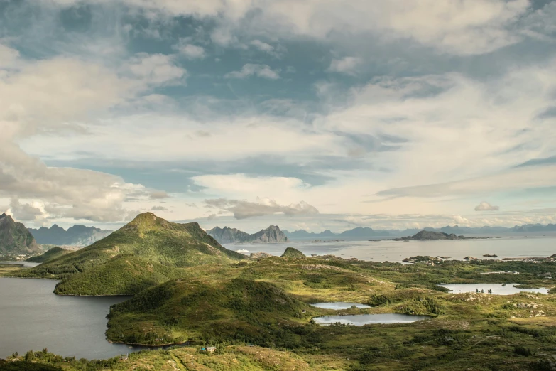 a grassy mountain landscape with a body of water in the background