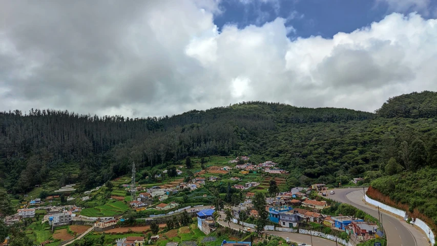 a street, parking lot and mountains covered in trees