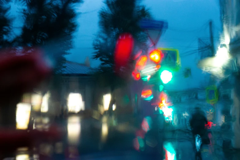 blurry pograph of traffic lights on a busy street at night