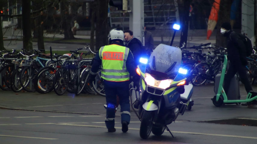 two police officers standing around motorcycles with one of them glowing