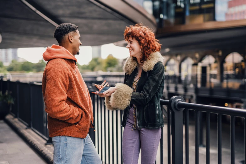 a woman is standing next to a man looking at soing