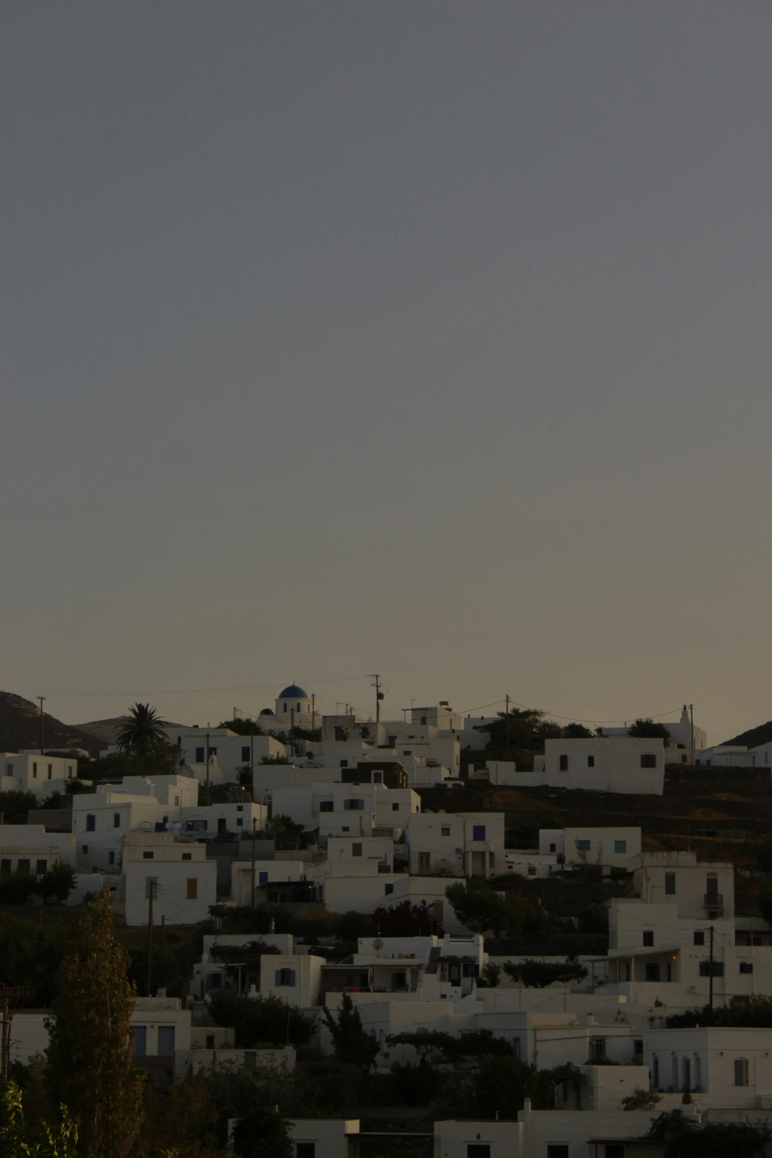 white houses at the top of a hill with a clock on top