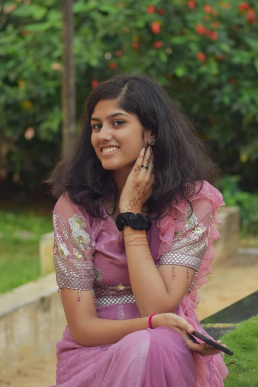 a girl in a pink dress talking on her phone