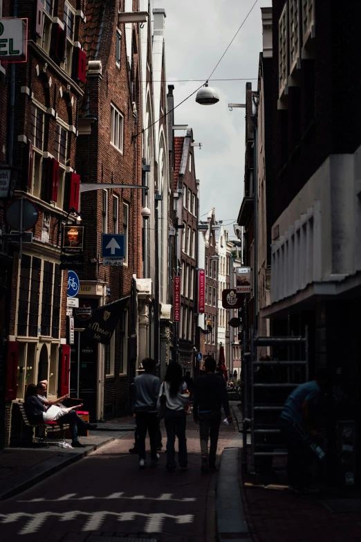 there are people walking down this street in the old part of town