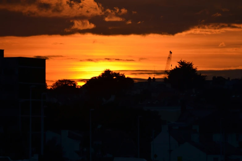 a city sky filled with clouds and sunset behind buildings