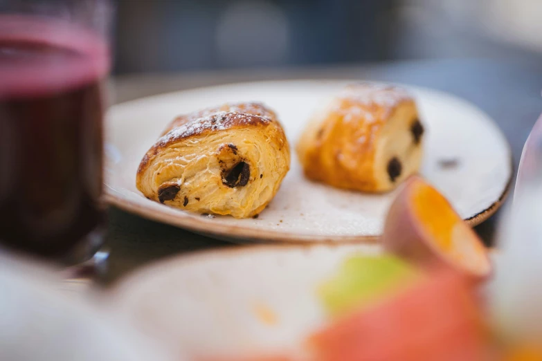 two pastries on a plate next to a cup