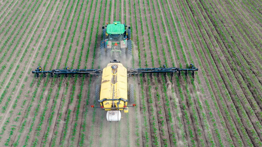 an image of an aerial view of a tractor harrowing crops