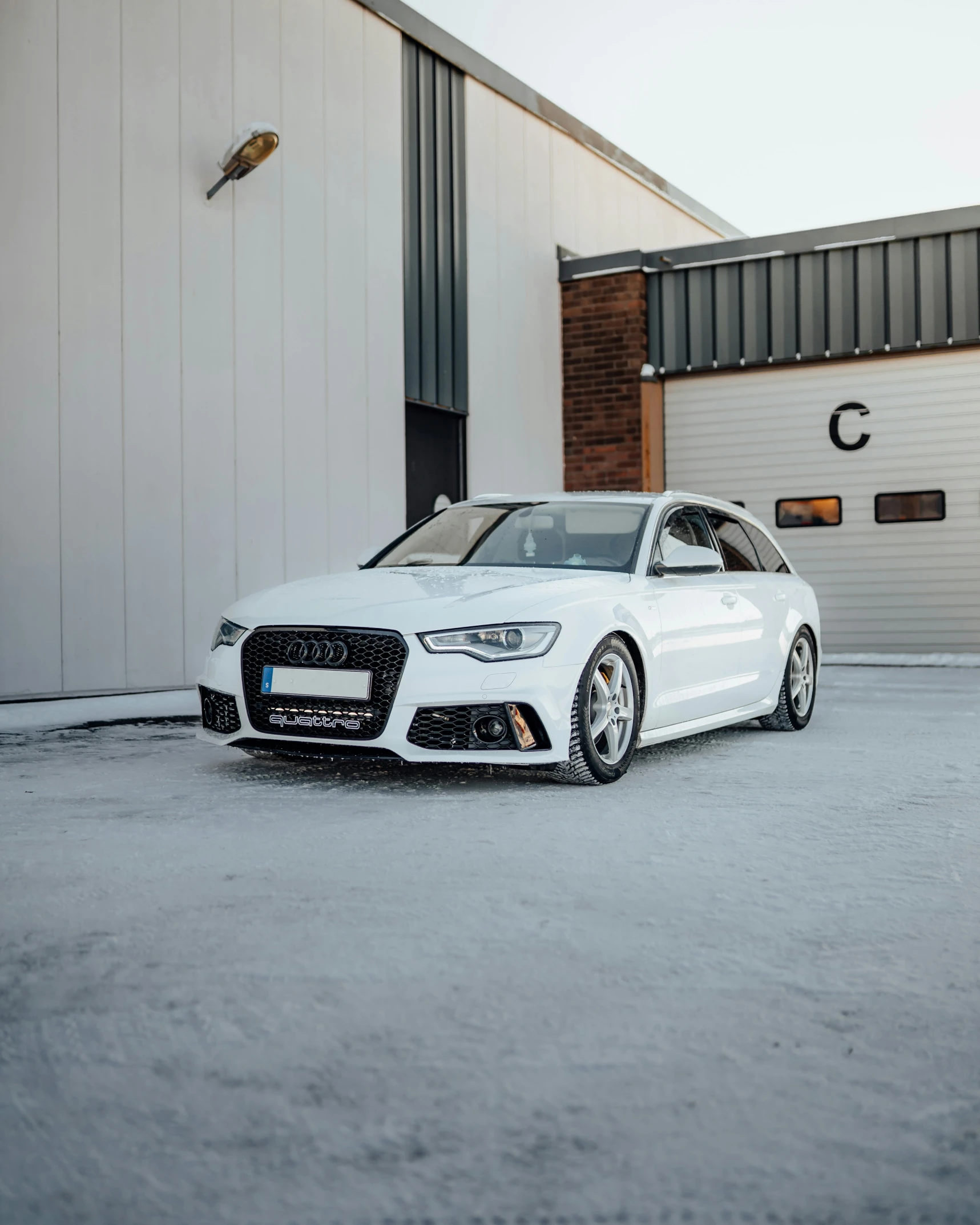 a white car is parked near a hangar