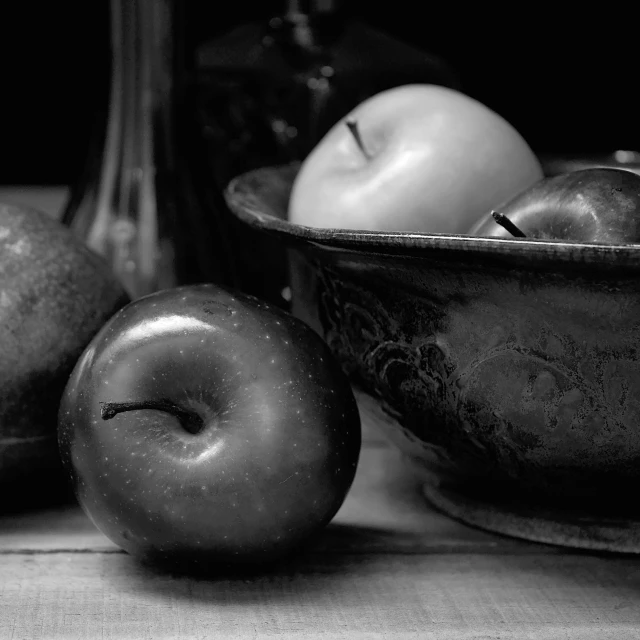 an apple and two other apples sitting in a bowl