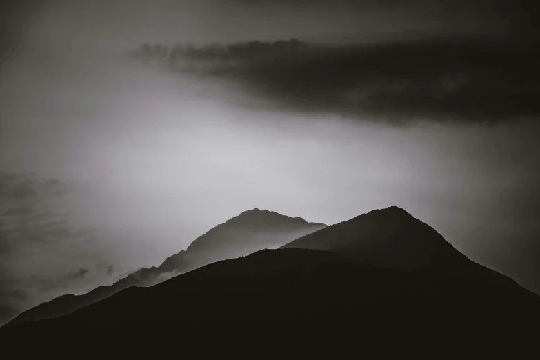 the sun shining through the clouds as it peeks into the mountain