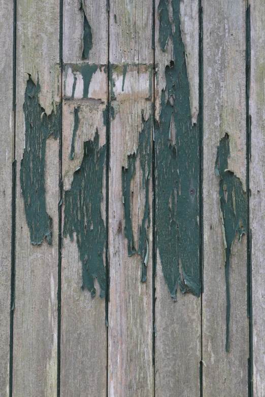 peeling paint on the side of a weathered wooden fence
