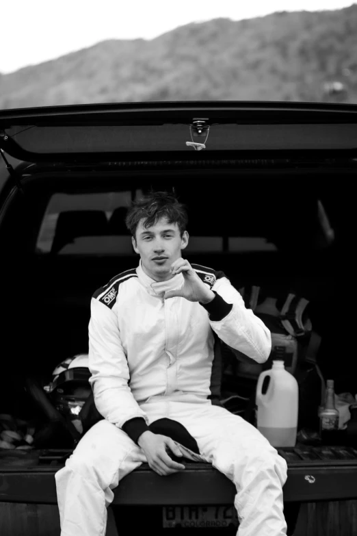 a man wearing all white sitting in a truck