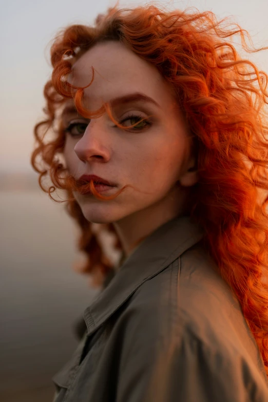 woman with orange hair and makeup on a beach