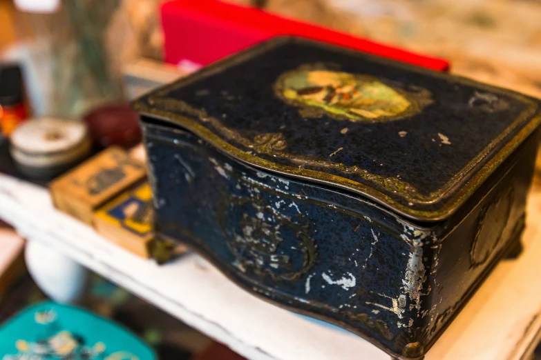 a black box with a golden lid sitting on a white counter