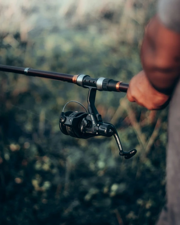 a person holding a fishing rod with a reel attached