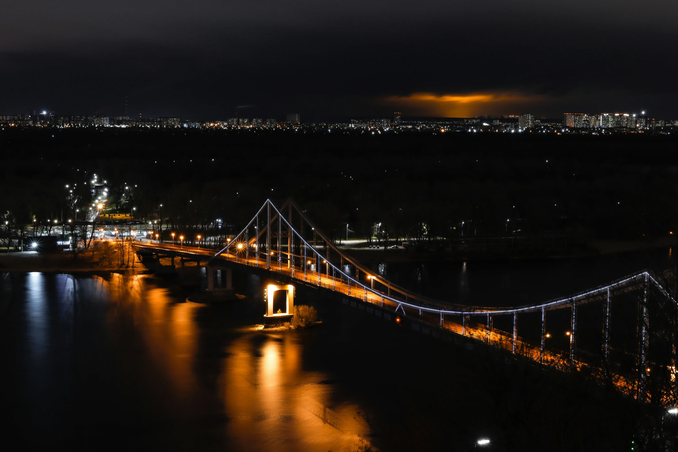 night time image with illuminated lights from different sides of the bridge