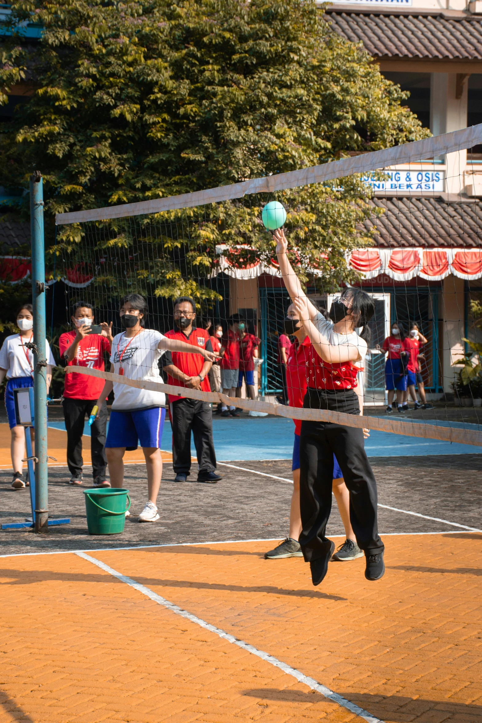 a man with a volley ball at a tennis court