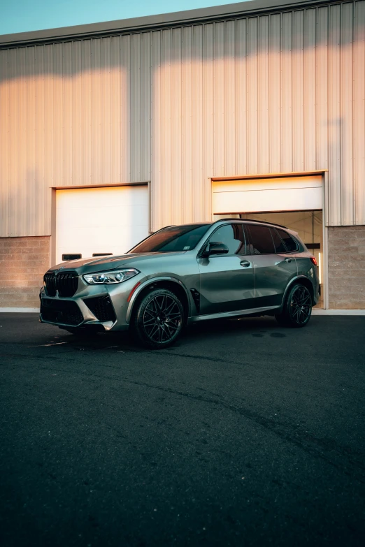 a bmw suv parked in front of a garage