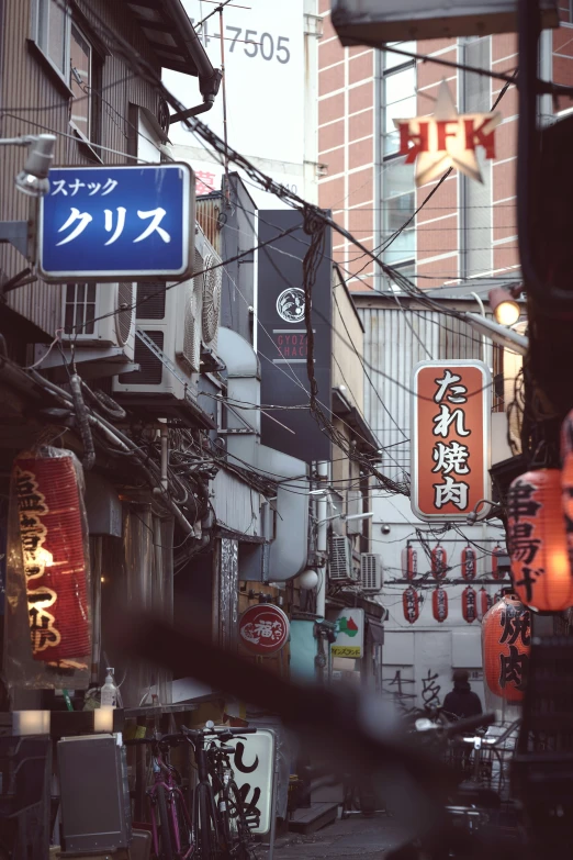 an asian street with signs and signs hanging off buildings