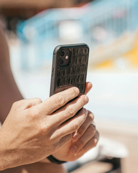 someone is holding up a black cell phone