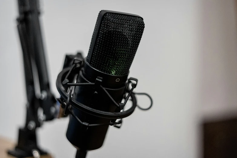 a black microphone sitting on top of a wooden desk