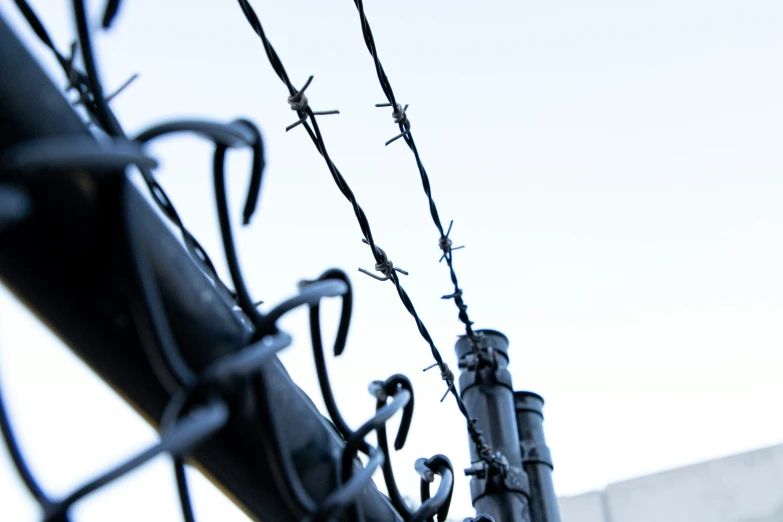 a close up of barbed wire and steel poles