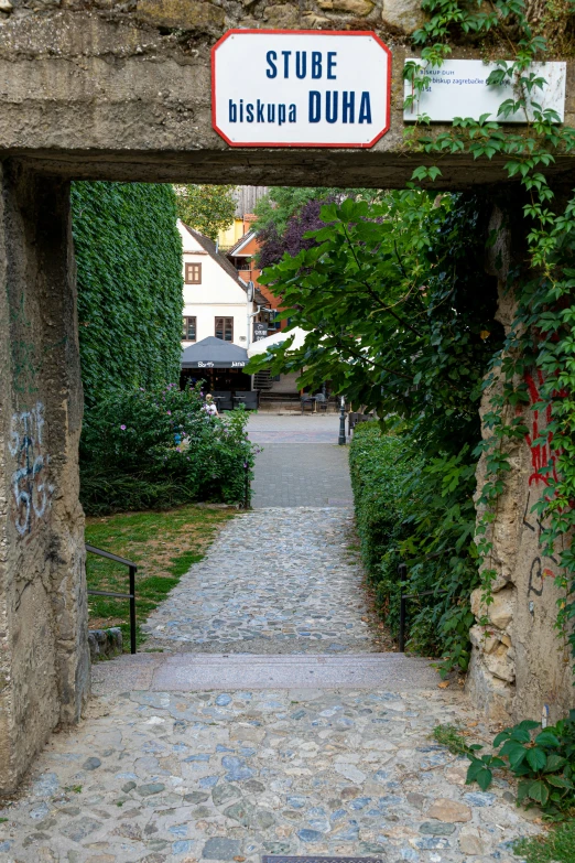 the pathway has graffiti all over it and a sign above it